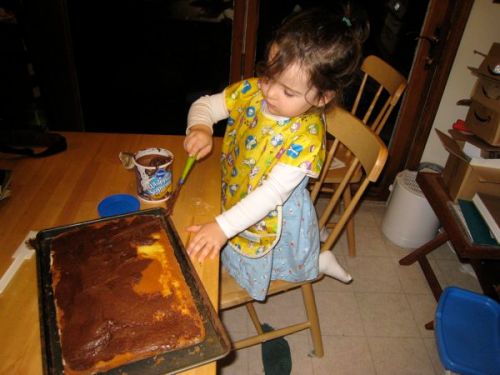 Phoebe helps frost the cake. (This photo does not show her stabbing the cake in her enthusiasm for the task.)