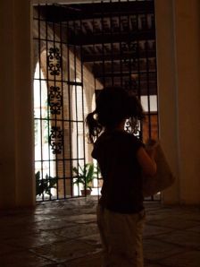 Phoebe peers through a gate at Alcazar in Sevilla.